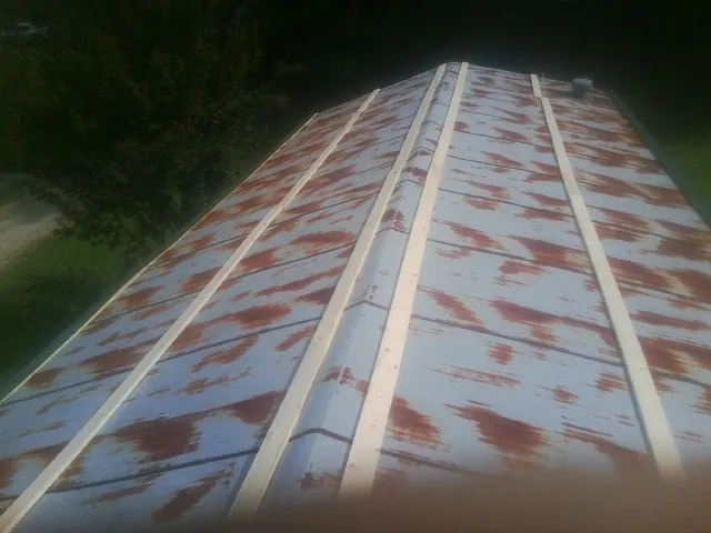 Rusted metal roof panels with new wood purlins before replacement — Storm Damage Roof Repair in Arnaudville by Roofing Brothers