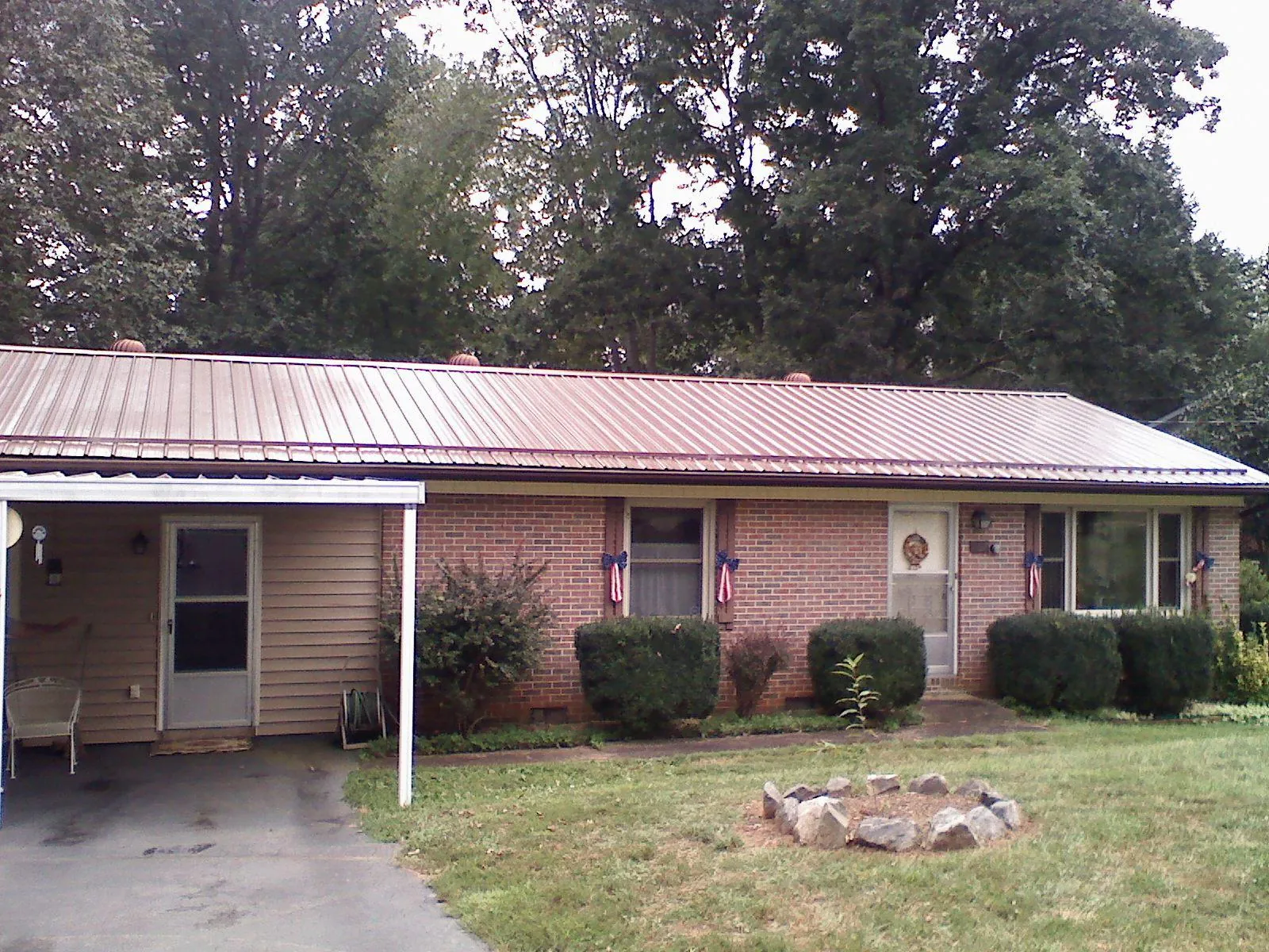 Bronze metal roof and carport on a brick ranch home — Roof Repair work by our crew in Arnaudville