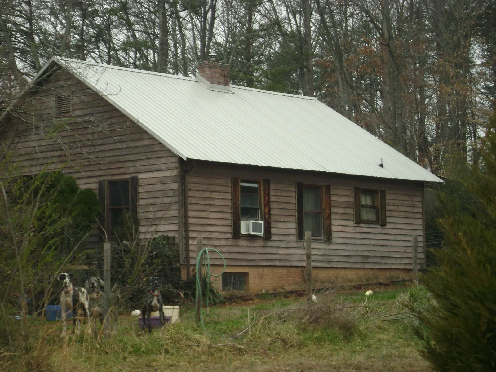 White metal roof on an old wood sided farmhouse, from a Metal Roof Installation job in Arnaudville